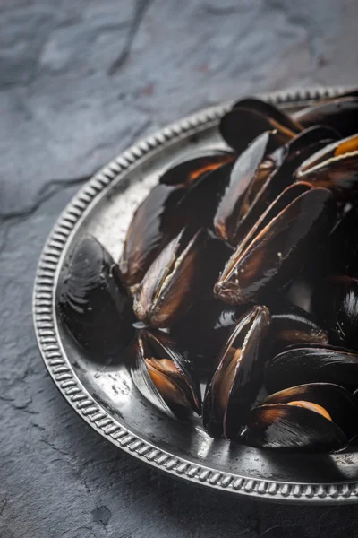 Folds mussels on an old metal plate on a slate — Stock Photo, Image