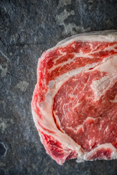 Piece of Ribeye steak on a marble gray-blue slate — Stok fotoğraf