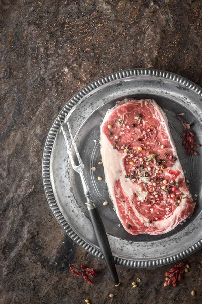 Pedazo de bistec de ribeye en plato de mármol de estaño, tenedor y barbero ber —  Fotos de Stock