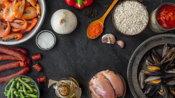 Ingredienti per la paella sul tavolo in pietra scura orizzontale — Foto Stock