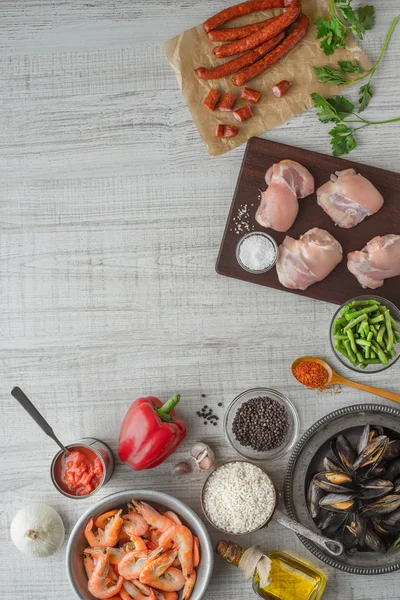 Ingredienti per paella sul tavolo in legno bianco verticale — Foto Stock