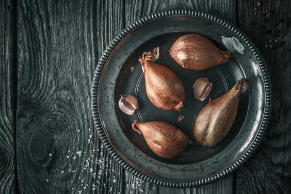 Shallot in the metal plate on the wooden table top view — Stock Photo, Image