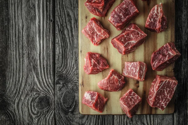 Rebanadas de carne cruda angus en la vieja vista superior de la mesa de madera —  Fotos de Stock