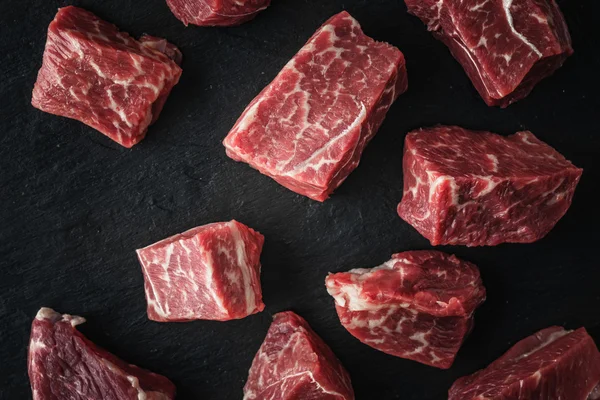 Rebanadas de carne cruda angus en la vista superior de la mesa de piedra negra —  Fotos de Stock