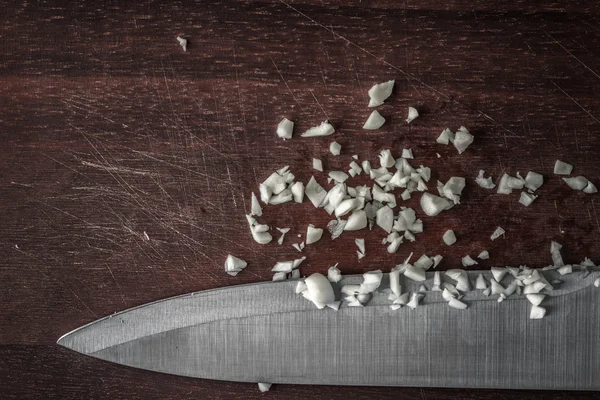 Нарезанный лук с ножом на деревянной доске горизонтально — стоковое фото