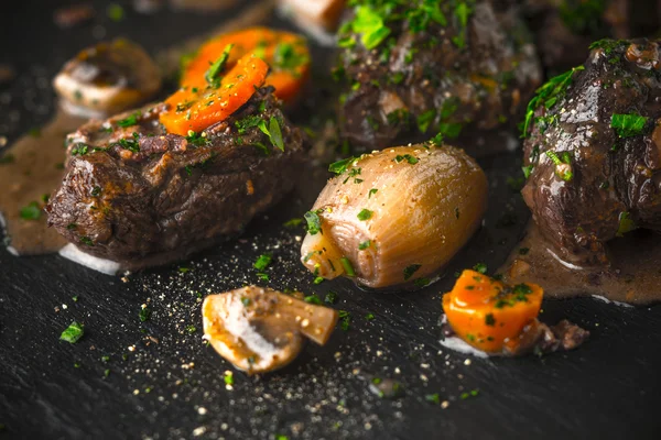Rindfleisch Bourguignon, Pfeffer und Sauce auf schwarzem Stein — Stockfoto