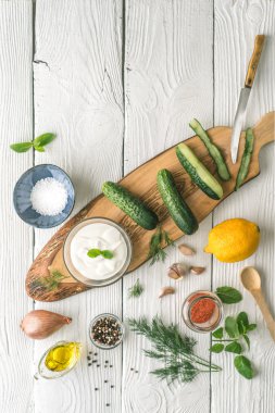 Dikey beyaz tabloda cacık hazırlık için malzemeler