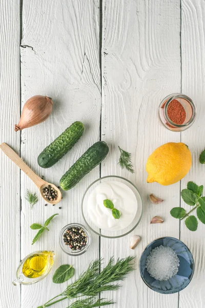 Ingredientes para la preparación de tzatziki en la mesa de madera blanca vertical — Foto de Stock