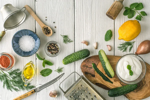 Zutaten für Tzatziki-Zubereitung auf der weißen Holztischplatte — Stockfoto