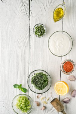 Doğal yoğurt ve dikey Beyaz ahşap masa üzerinde farklı baharat