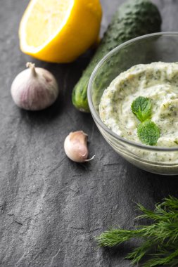 Malzemeler dikey ile siyah taş tabloda cacık