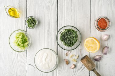 Doğal yoğurt ve farklı baharat beyaz ahşap masa üstü üzerinde göster