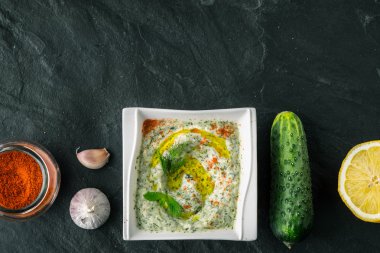 Salatalık, limon ve baharat ile taş tabloda cacık