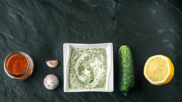 Tzatziki en la mesa de piedra con pepino, limón y condimento pantalla ancha — Foto de Stock