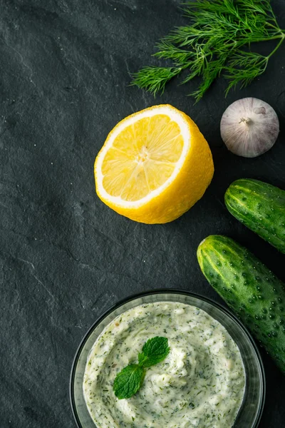 Tzatziki en la mesa de piedra oscura con ingredientes verticales —  Fotos de Stock