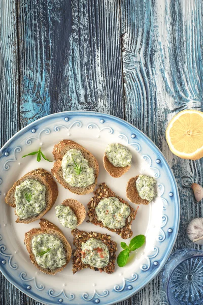 Placa com pão diferente com tzatziki na vista superior da mesa de madeira azul — Fotografia de Stock