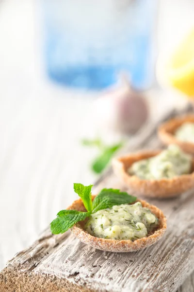 Pão crocante com tzatziki na tábua de madeira branca — Fotografia de Stock