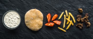 Gyros için hazır malzemelerin üzerine siyah taş