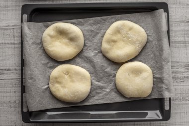 Ahşap bir masaya pişirme pide, parşömen,