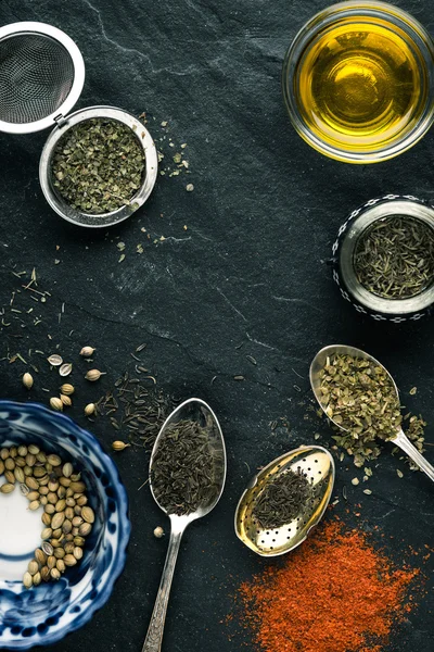 Spices, paprika, spoon, butter, ceramic plate on a black slate — Stock Photo, Image