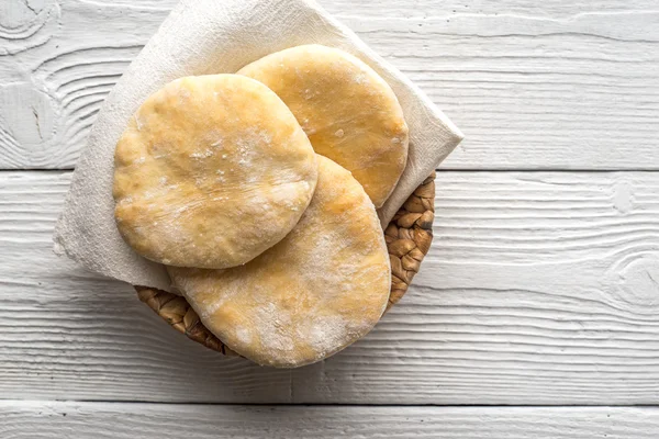 Pita, um guardanapo, um cesto em uma mesa de madeira — Fotografia de Stock