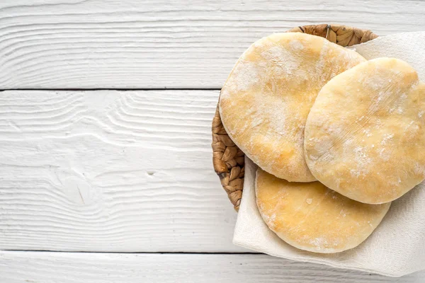 Pita, um guardanapo, um cesto em uma mesa de madeira à direita — Fotografia de Stock