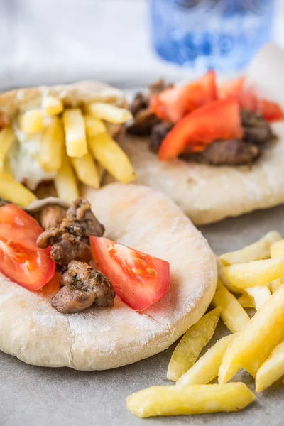 Pita gyros, patate fritte, pomodoro, carne su pergamena — Foto Stock