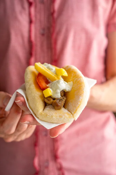 Greek gyros in female hands on a pink background — Stock Photo, Image