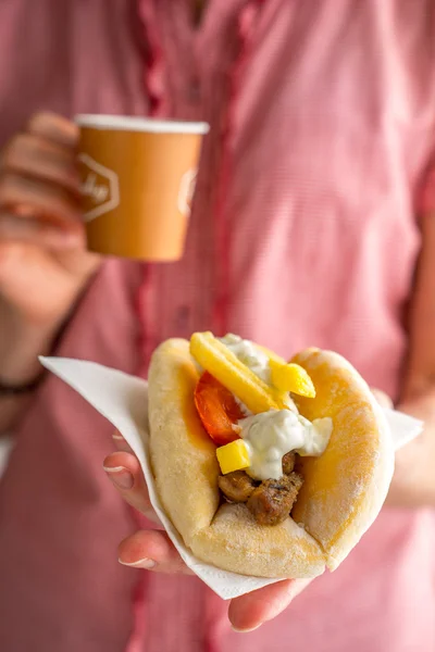 Greek gyros and cup of coffee in female hands on a pink backgrou — Stock Photo, Image
