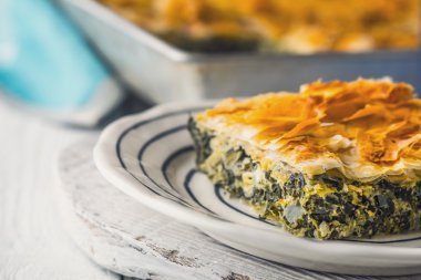 Yunan pasta spanakopita yatay beyaz masada seramik plaka