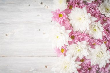 Beyaz ahşap masa üstü beyaz ve pembe çiçekler göster