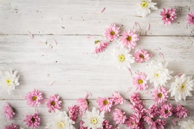 Beyaz ahşap masa üstü pembe ve beyaz çiçekler göster