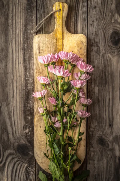 Flores cor de rosa na vista superior da placa de madeira — Fotografia de Stock