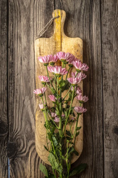 Flores cor de rosa na tábua de madeira vertical — Fotografia de Stock