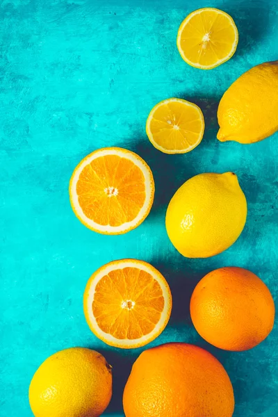 Limones y naranjas sobre el fondo cian vertical —  Fotos de Stock