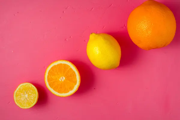 레몬과 오렌지는 밝은 핑크 배경 위에 보기 — 스톡 사진