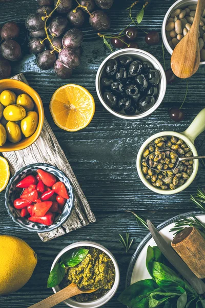 Begreppet medelhavsmat. Olika frukter, örter och aptitretare på träbord vertikala — Stockfoto