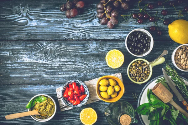 概念的地中海菜肴。不同水果、 香草和蓝色的木桌上的开胃菜 免版税图库图片