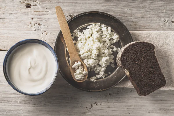 Färska keso på metallplattan med bröd på vyn vit trä bordsskiva — Stockfoto