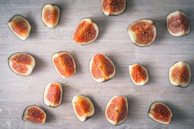 Beyaz ahşap arka plan üst görünümünde dilimlenmiş incir