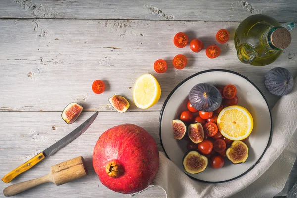Ингредиенты для фруктового салата с помидорами на белом деревянном столе — стоковое фото