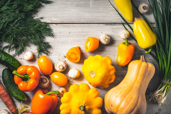 Yellow and green vegetables on the white wooden table top view — Stock Fotó