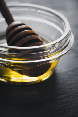 Bal ve bal ayı karanlık taş masanın üzerinde bir cam kase