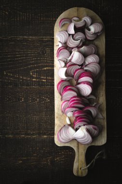 Ahşap tahta üzerinde dikey kırmızı soğan dilimlenmiş