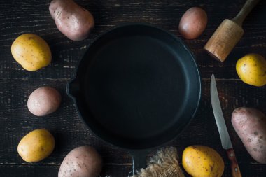 Ahşap masa üstü görüntüsü üzerinde ham patates çevrili pişirme pan