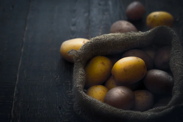 Patate nella borsa di tela sul tavolo di legno orizzontale — Foto Stock