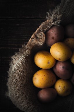 Patates çanak üzerinde tuval üzerine ahşap masa dikey karıştırın