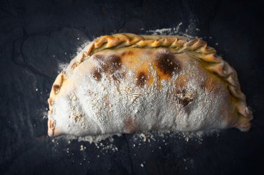 Pizza Calzone un koyu taş ile arka plan Üstten Görünüm