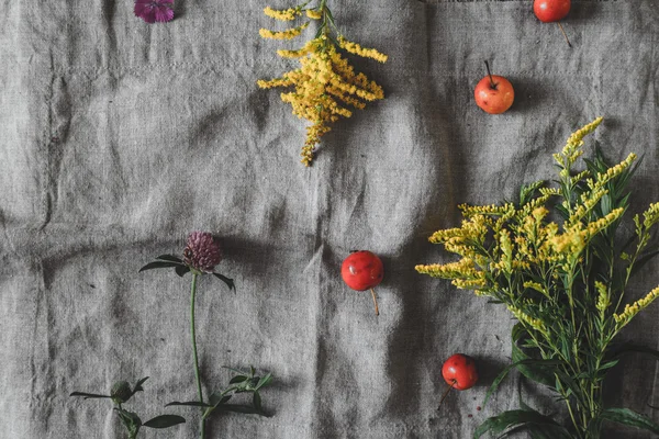 Flores de outono e maçãs na vista superior de pano cinza — Fotografia de Stock