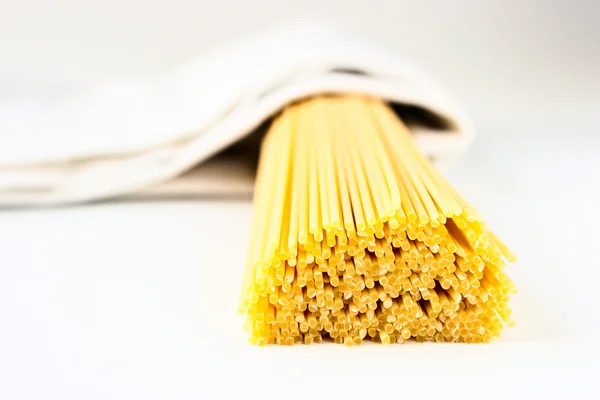 Raw pasta in a white towel on the white background — Stock Photo, Image